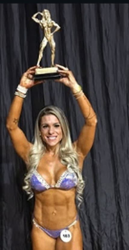 Dayene Mormano erguendo o troféu no palco